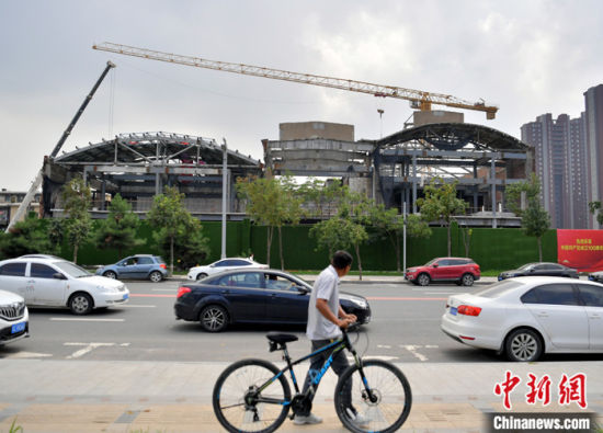 8月15日，吉林省长春市，一名市民从长春拖拉机厂工业遗址改造现场外经过。 中新社记者 张瑶 摄