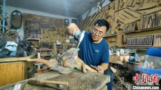 郝荣田正在对松花江浪木进行炭化处理。 石洪宇 摄 郝荣田正在对松花江浪木进行炭化处理。 石洪宇 摄